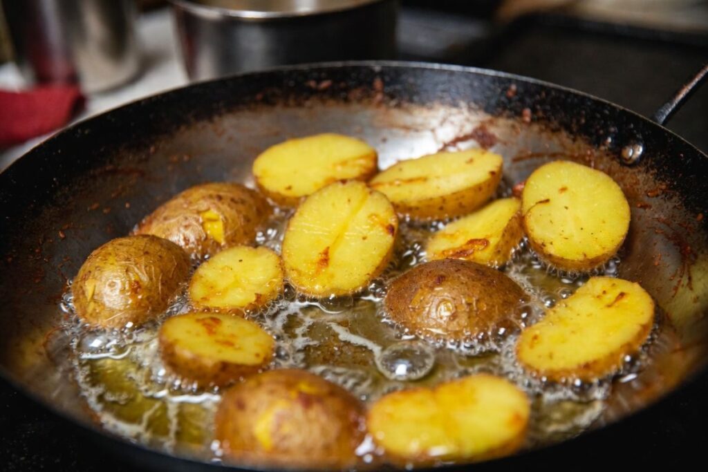 Frying potatoes in ghee for authentic Kolkata chicken dum biryani