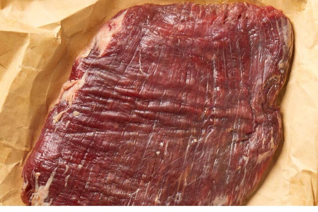 Thinly sliced flank steak cut against the grain, showing its tender texture and perfectly cooked strips for stir-fry for Beef Steak with Broccoli Recipe