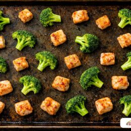 A large baking sheet with chicken cubes and broccoli spaced out evenly to ensure perfect roasting and air circulation.