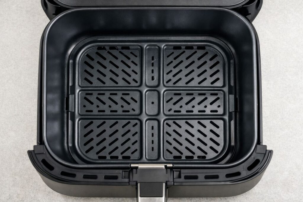 Empty square basket of a 6-quart Cosori air fryer with ceramic nonstick coating