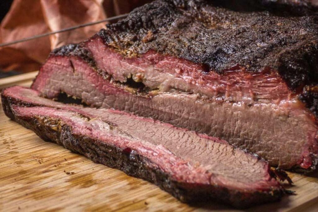 Close-up of brisket with soft, pale, and mushy bark showing lack of crust formation due to poor smoking technique or moisture retention.